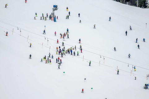 Ski lessons and many skiers on a ski slope with drag lift, view from above, Hochbrixen in winter,