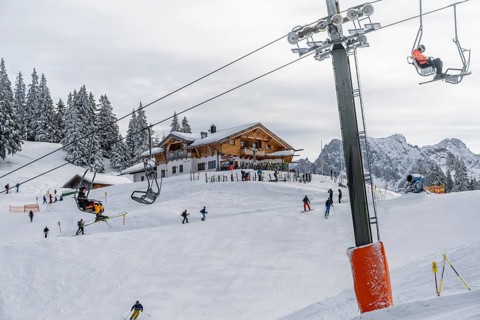 Kreuzeckbahn ski lift and ski hut Kreuzalm, skiers in the Garmisch Classic ski area in winter,