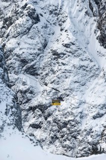 View of snowy mountains with yellow Alpspitzbahn gondola, view from Längenfelderkopf in winter,