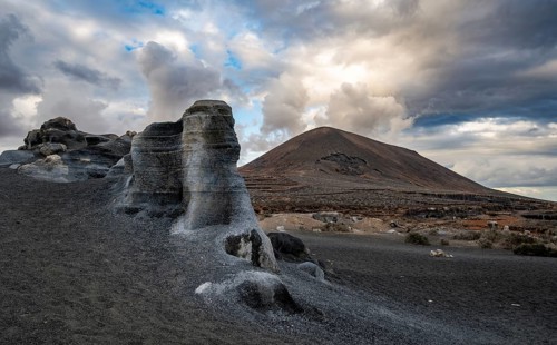 Eroded rock formations, volcanic landscape with dramatic cloudy skies, Ciudad Estratificada or Los