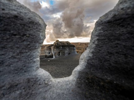 Eroded rock formations, volcanic landscape with dramatic cloudy sky at sunset, Ciudad Estratificada