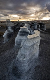 Eroded rock formations, volcanic landscape with dramatic cloudy sky at sunset, Ciudad Estratificada