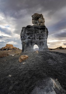 Eroded rock formations with rock tunnels, volcanic landscape with dramatic cloudy skies, Ciudad