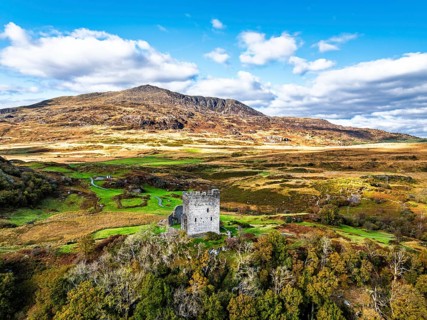 Autumn colours over Castell Dolwyddelan and Eryri Mountains from a drone, Snowdonia, Conwy County