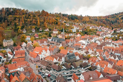 View of a picturesque town with numerous half-timbered houses and surrounding autumn forests, Calw,