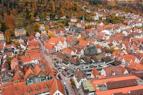 Aerial view of a historic old town with reddish brown roofs and half-timbered houses in autumn,