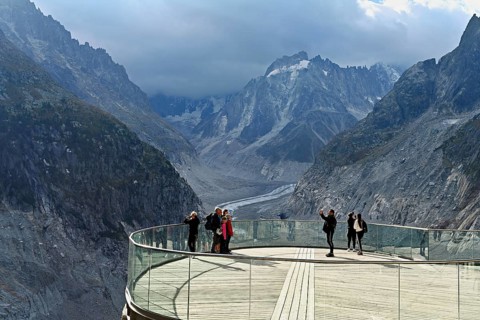 A group of people take pictures of themselves on the viewing platform in front of the Mer de Glace