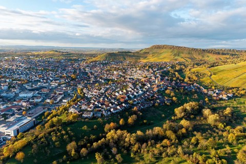 Panoramic picture of a village in evening light surrounded by hills and nature, autumn,