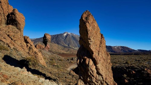 Volcanic rock formations in dry landscape with blue sky, UNESCO World Heritage Site, Teide National