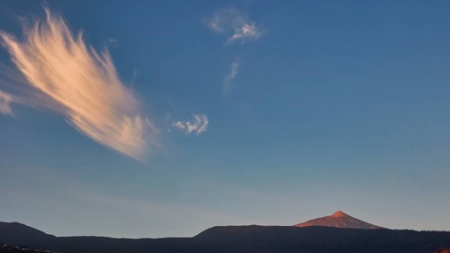 Striped clouds in the evening sky over a distant volcano in soft light, UNESCO World Heritage Site,