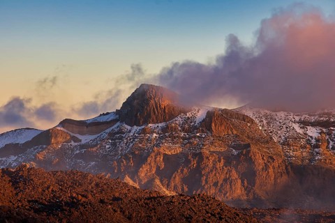 Rugged mountain landscape in the light of the setting sun, surrounded by clouds, UNESCO World