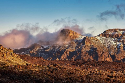 Steep mountains in the evening light with fog and clouds that create a mystical atmosphere, UNESCO