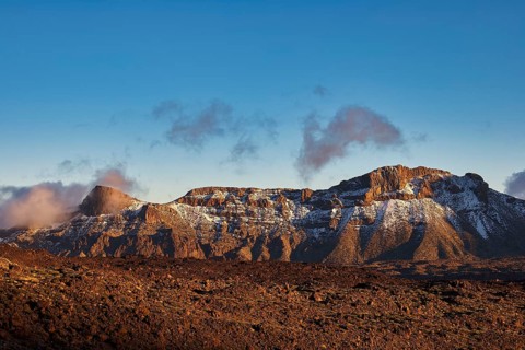 Snowy mountain range under clear blue sky with some clouds, UNESCO World Heritage Site, Teide