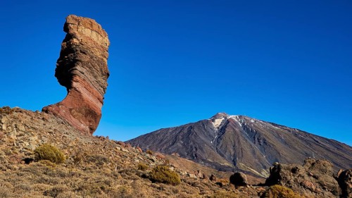 Distinctive rocky outcrop in front of volcano in barren surroundings, UNESCO World Heritage Site,