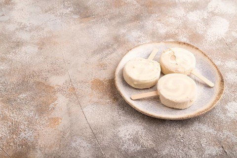 ?hocolate Ice cream in white glaze, on brown concrete background, side view, copy space, minimalism