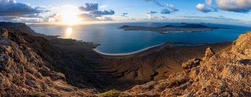 View of steep cliffs to sea and the island of La Graciosa, Mirador del Porrito viewpoint at sunset,