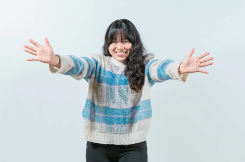 Friendly asian girl welcoming with open arms isolated. Beautiful asian woman welcoming you with