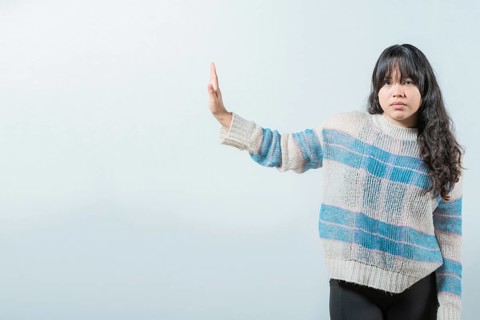 Asian girl making rejection gesture with palm of hand isolated. Displeased asian woman rejecting
