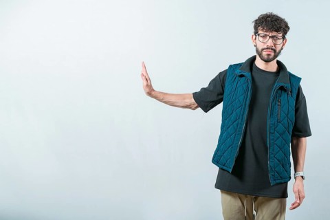 Serius guy making rejection gesture with palm of hand isolated. Displeased young man ignoring with