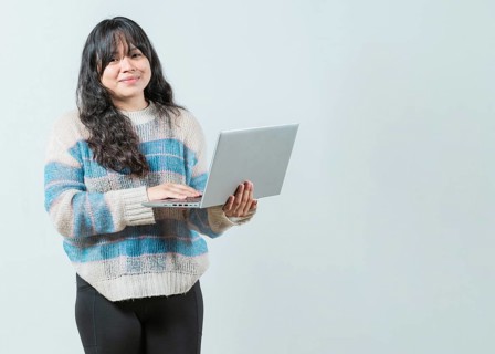 Smiling asian woman using notebook and looking at camera with copy space. Beautiful asian girl