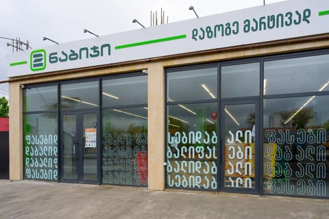 Modern shop front with shop windows and lettered signs in an urban environment, supermarket,