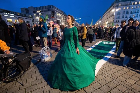 Athena Macke (costume designer) wears a dress with a long train in the shape of a bike path (bike