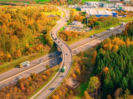 Traffic on a road junction in an autumnal wooded area with blooming landscape, A8 near Rutesheim,