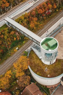 Aerial view of an observation tower with bridge over railroad tracks, surrounded by autumn leaves,