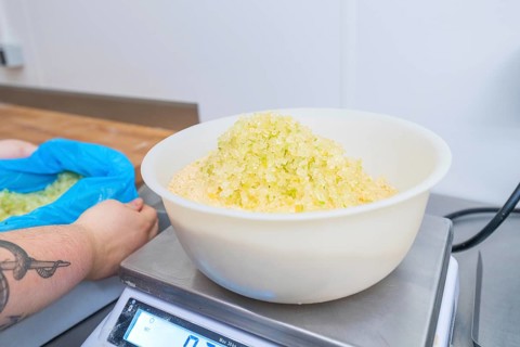 Person holding bags while bowl of sugar is on the scale in a kitchen, Christmas baking,