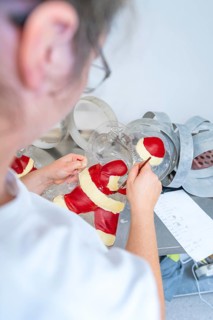 Person decorating a Santa Claus mold with red and white paint, Christmas baking, Haselstaller Hof,