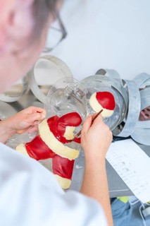 Person paints a Santa Claus mold with red and white tint, Christmas baking, Haselstaller Hof,