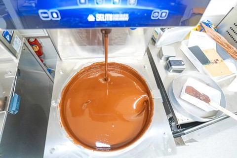 Chocolate machine with liquid chocolate in a commercial kitchen, Christmas baking, Haselstaller