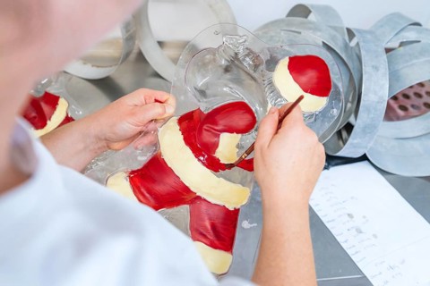 A person paints details in a chocolate Santa Claus mold, Christmas baking, Haselstaller Hof,
