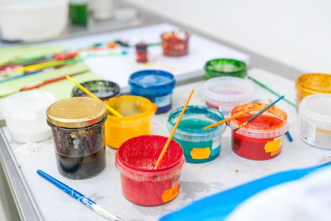 Colourful painting supplies on a table with coloured containers and brushes, Christmas baking,