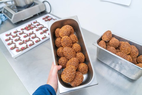 Various rectangular metal containers full of brown chocolate chocolates in a kitchen, Christmas