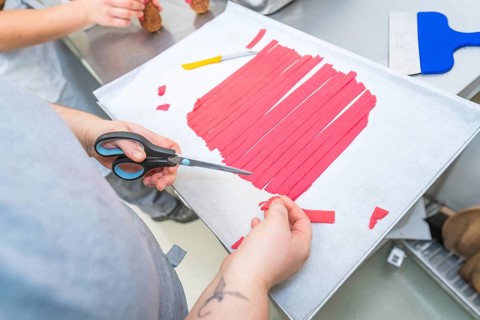 Red strips are cut with scissors on a baking sheet, Weihnachtsbacken, Haselstaller Hof, Wildberg,