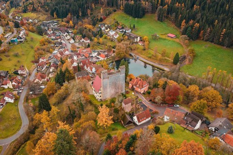 A castle and an idyllic village on a river surrounded by autumn trees, Berneck Castle, Altentsteig,