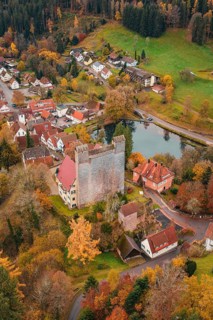 A castle next to a river in the middle of an autumn-colored village, Berneck Castle, Altentsteig,