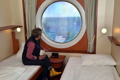 Woman looking out of her ship cabin at the sea, Baltic Sea, Color Line ferry, Schleswig-Holstein,