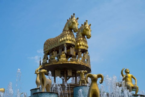 Close-up of golden horses and ram statues above a fountain under a blue sky, Colchis Fountain,