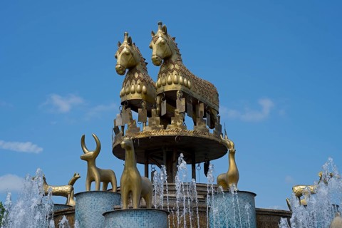 An impressive fountain with golden horse and ram statues under clear skies, Colchis Fountain, David