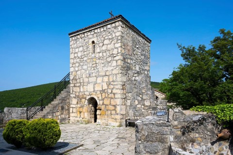 Historic stone tower with small garden and side stairs in a quiet area, Motsameta monastery, near