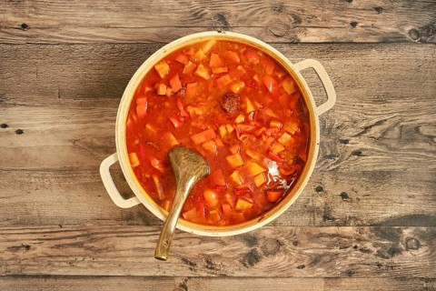 Top view of a hearty beef stew in a large pot, filled with tender beef chunks, colorful vegetables,
