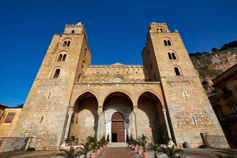Impressive cathedral with symmetrical towers and arches under clear blue sky, Cefalu, cathedral,