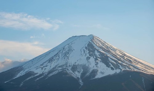 Snow-covered summit of Mount Fuji volcano in spring, in evening light, Arakurayama Sengen Park,