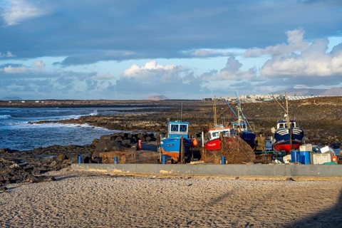 Colourful fishing boats at the port of La Santa, coast with volcanic rocks, La Santa, Lanzarote,