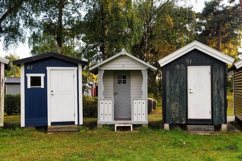 Three different beach huts in a meadow, Ystad, Sweden