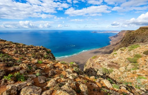 View from the Risco de Famara cliffs to the coast and the sea with the Famara beach, Playa de