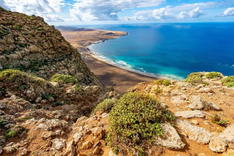 View from the Risco de Famara cliffs to the coast and the sea with the Famara beach, Playa de