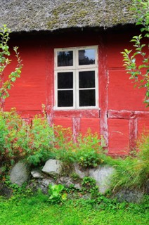 Window in red wall of half-timbered house with thatched roof in Den gamle by, The old village, open